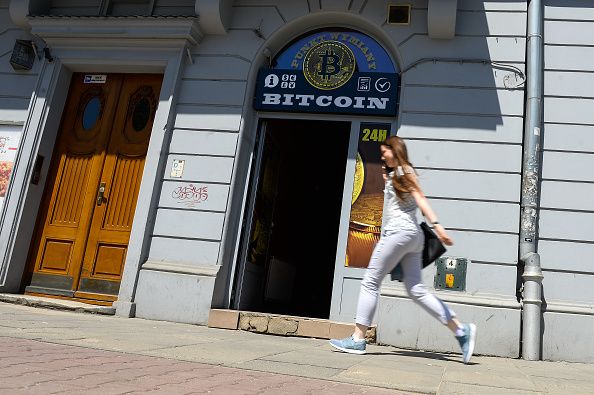 سيدة تمر أمام متجر لصرافة «بيتكوين» في وسط مدينة كراكوف، بولندا (غيتي)